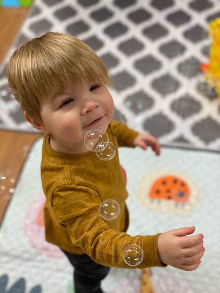 Child popping bubbles during Tiny Tales Story Time