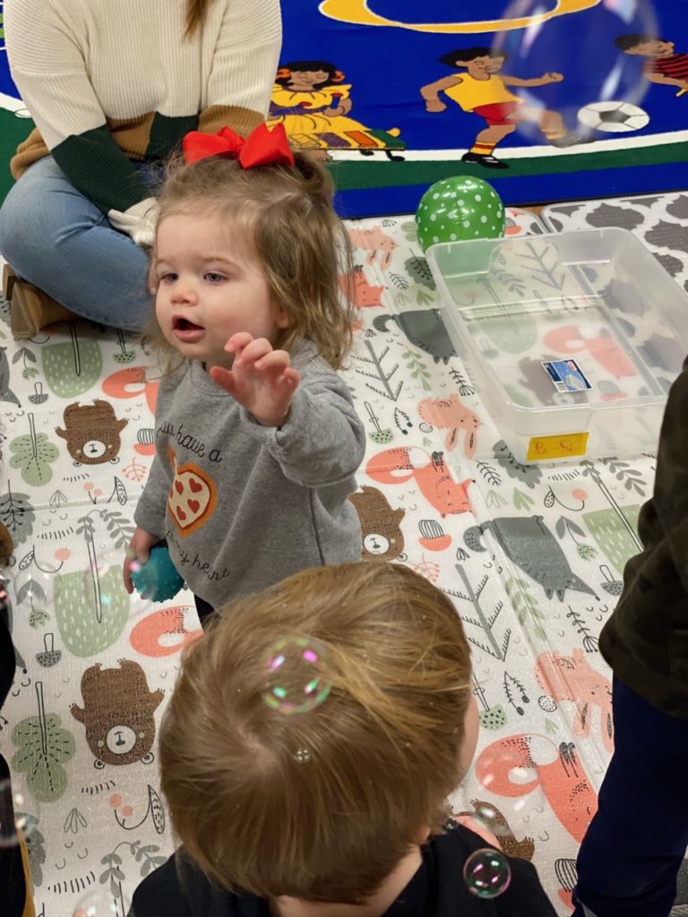 Two children enjoying bubbles during Tiny Tales Story Time