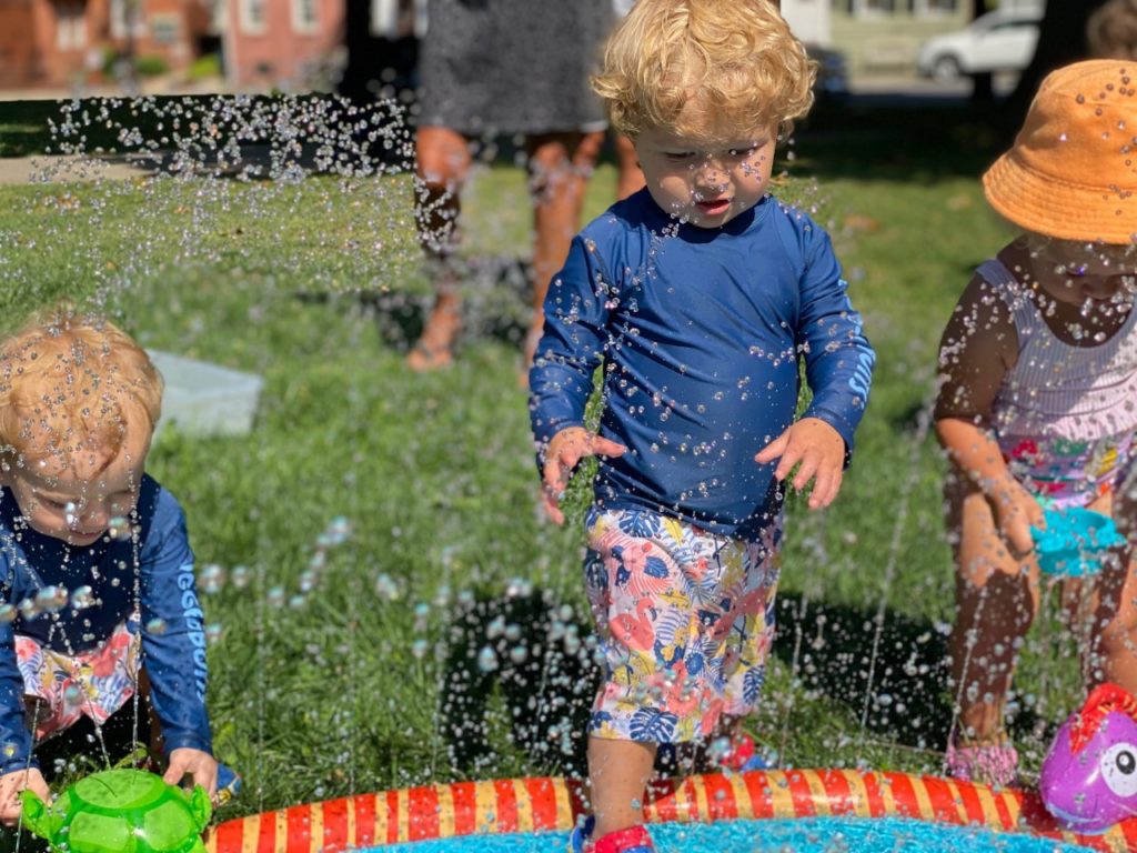 Children playing in a sprinkler splash pad.