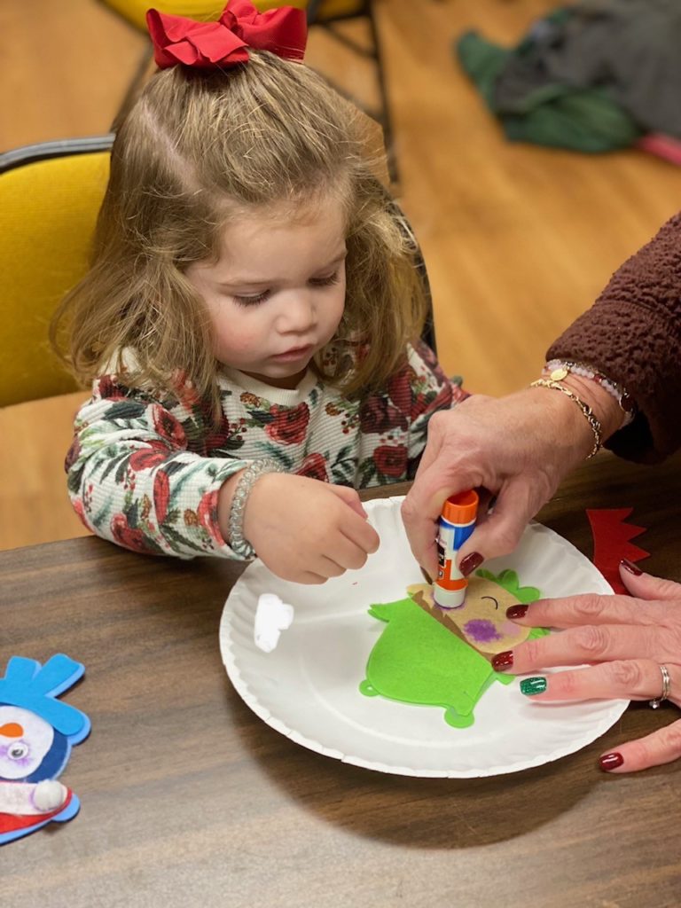 Child doing craft during story time program.